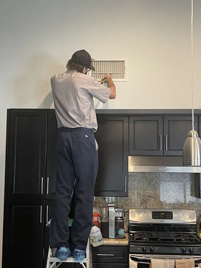 Technician inspecting an air vent during HVAC service in Bellingham